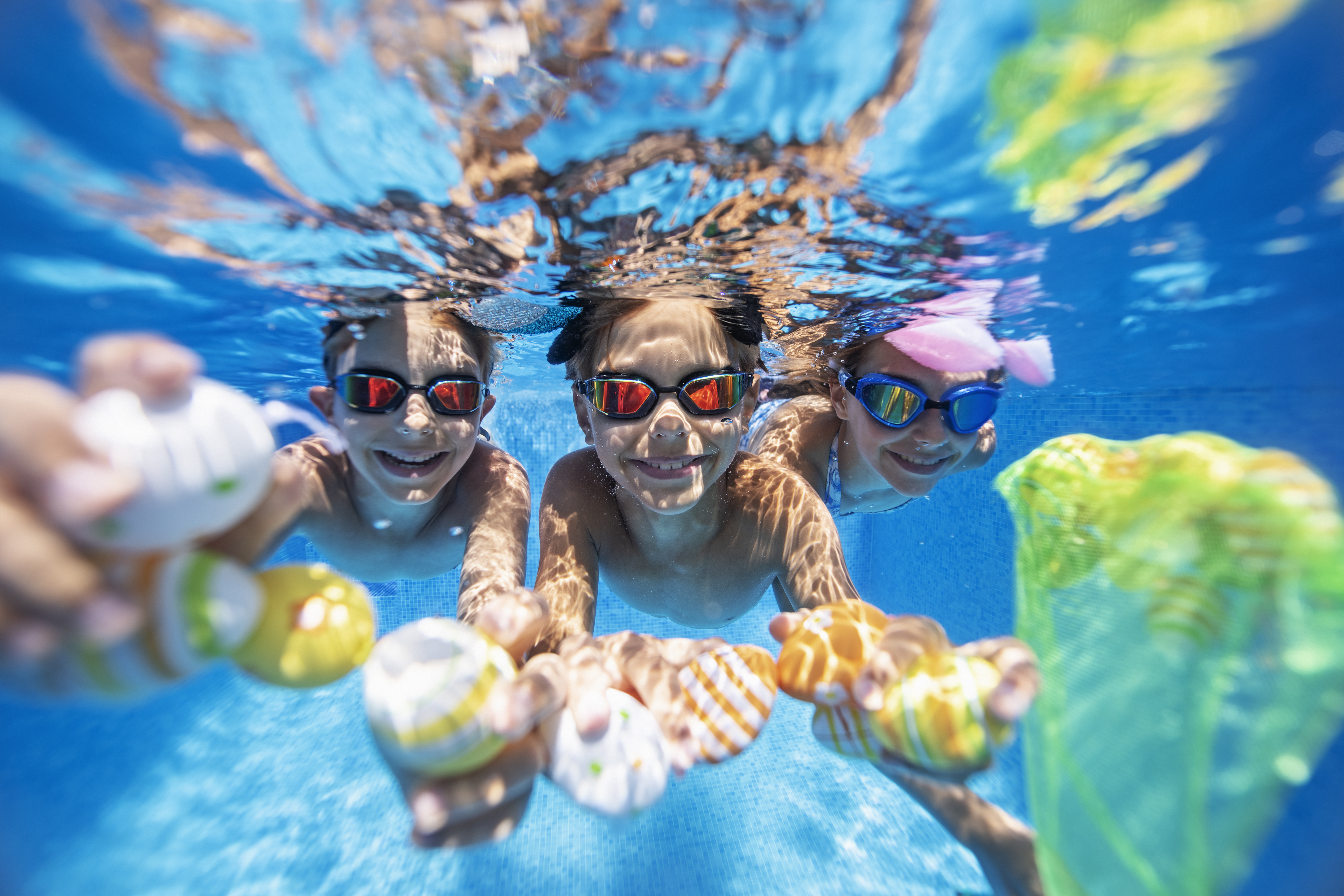 3 kids swimming under the water