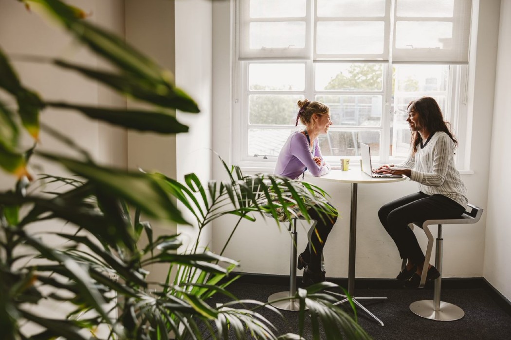 2 woman sitting together by the window.